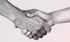 Black and white close-up of two hands shaking each other in a gesture of agreement or greeting.